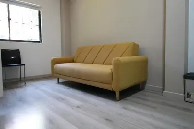 a yellow couch in a room with a television at Económica Suite en sector Manila el Poblado M102 By Roots Rentals in Medellín