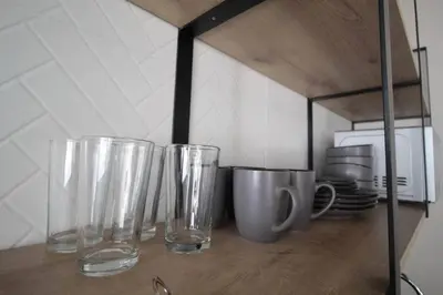 four empty glasses sitting on a shelf in a kitchen at Hospedaje cerca a Provenza en el Poblado - M301 By Roots Rentals in Medellín