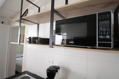 a kitchen with a microwave above a kitchen counter at Hospedaje cerca a Provenza en el Poblado - M301 By Roots Rentals in Medellín