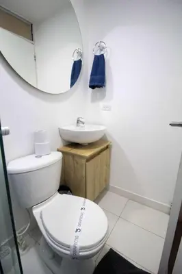 a bathroom with a toilet and a sink and a mirror at Hospedaje cerca a Provenza en el Poblado - M301 By Roots Rentals in Medellín