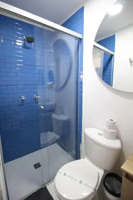a blue tiled bathroom with a toilet and a shower at Hospedaje cerca a Provenza en el Poblado - M301 By Roots Rentals in Medellín
