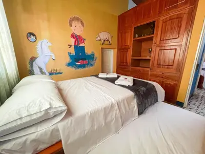 a bedroom with two beds and a painting on the wall at Casa Los Patios in Jericó