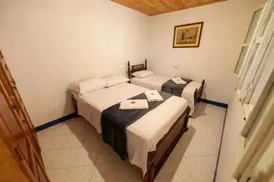 a room with three beds with towels on them at Casa Los Patios in Jericó