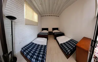 a group of four beds in a room at VILLA CARO in Palestina