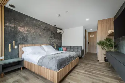 a bedroom with a large bed and a concrete wall at Apartamentos Go Living & Suites by HOUSY in Medellín