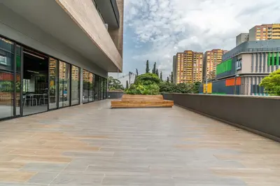 a walkway outside of a building with a fountain at Apartamentos Go Living & Suites by HOUSY in Medellín