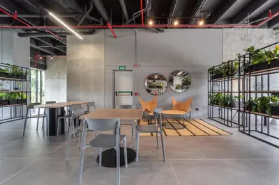 a dining room with tables and chairs and plants at Apartamentos Go Living & Suites by HOUSY in Medellín
