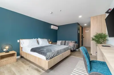 a bedroom with a bed and a blue wall at Apartamentos Go Living & Suites by HOUSY in Medellín
