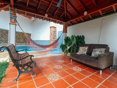 a porch with a couch and a hammock on a patio at KasaGrande in Santa Fe de Antioquia