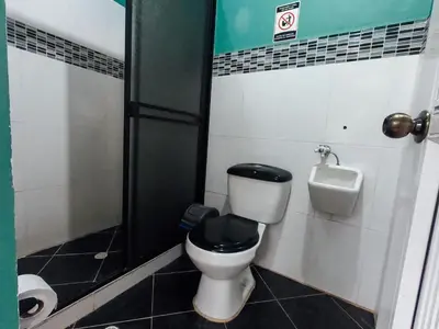 a bathroom with a toilet with a sink and a urinal at KasaGrande in Santa Fe de Antioquia