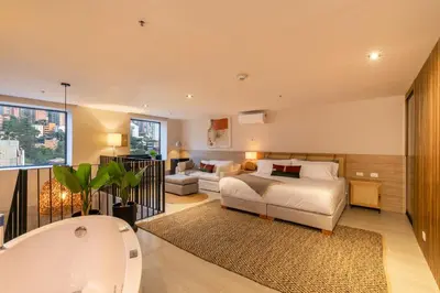 a bedroom with a bed and a living room at Landmark Hotel in Medellín