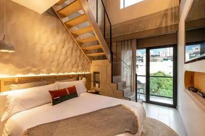 a bedroom with a large bed and a staircase at Landmark Hotel in Medellín
