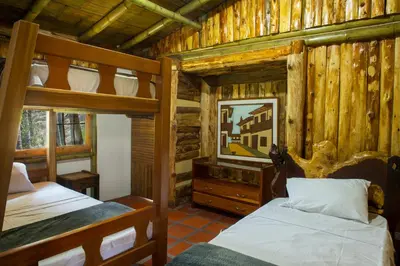 a bedroom with two bunk beds in a log cabin at Hacienda Charrascal Coffe Farm in Manizales