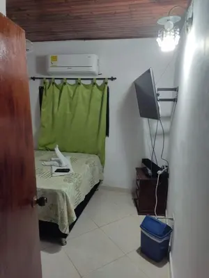 a small room with a bed and a television at Casa Puerto Triunfo Dann in Puerto Triunfo