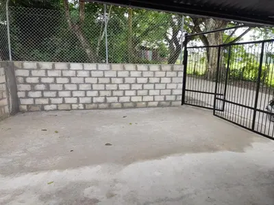 a garage with a gate and a brick wall at Casa Puerto Triunfo Dann in Puerto Triunfo