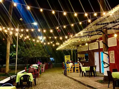 a patio with tables and chairs under a string of lights at Casa Puerto Triunfo Dann in Puerto Triunfo