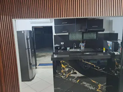 a kitchen with a black counter and a refrigerator at Casa Puerto Triunfo Dann in Puerto Triunfo
