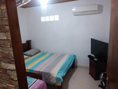 a small bedroom with a bed and a television at Casa Puerto Triunfo Dann in Puerto Triunfo