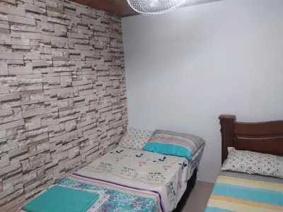 a bedroom with two beds and a brick wall at Casa Puerto Triunfo Dann in Puerto Triunfo
