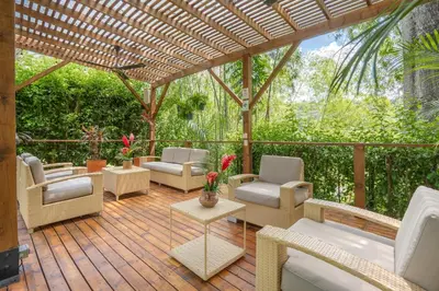 a wooden deck with chairs and a pergola at Casa Jacaranda Hotel Boutique -Cauca Viejo- Mayores de 14 años in Jericó