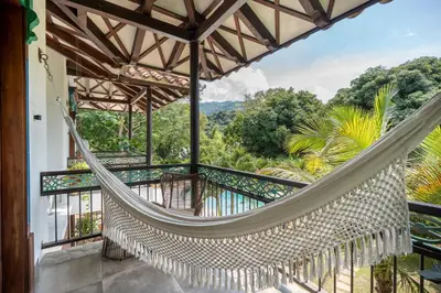 a hammock on the balcony of a house with a view at Casa Jacaranda Hotel Boutique -Cauca Viejo- Mayores de 14 años in Jericó
