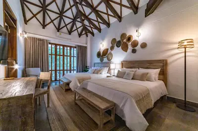 a bedroom with two beds and a table at Casa Jacaranda Hotel Boutique -Cauca Viejo- Mayores de 14 años in Jericó