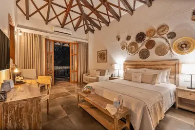 a bedroom with a bed and a living room at Casa Jacaranda Hotel Boutique -Cauca Viejo- Mayores de 14 años in Jericó