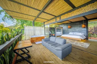 a bedroom with a bed and a couch and a table at Cabañas de Lujo en Medio de la Naturaleza in Don Matías