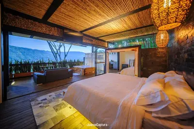 a bedroom with a large bed and a large window at Cabañas de Lujo en Medio de la Naturaleza in Don Matías