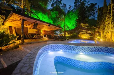 a resort with a pool with a green illumination at Cabañas de Lujo en Medio de la Naturaleza in Don Matías