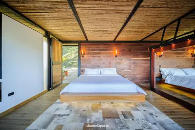 a bedroom with two beds and a wooden wall at Cabañas de Lujo en Medio de la Naturaleza in Don Matías