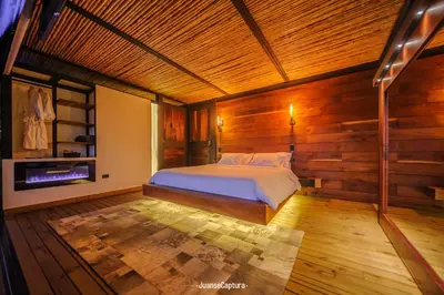 a bedroom with wooden walls and a bed in a room at Cabañas de Lujo en Medio de la Naturaleza in Don Matías