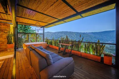 a living room with a couch and a table on a balcony at Cabañas de Lujo en Medio de la Naturaleza in Don Matías