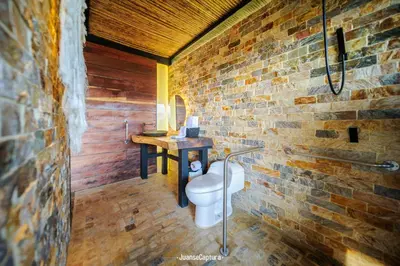 a bathroom with a brick wall and a toilet at Cabañas de Lujo en Medio de la Naturaleza in Don Matías