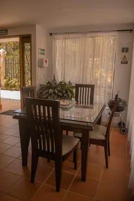 a dining room with a glass table and chairs at Hermosa casa de campo en GUATAPÉ in Guatapé