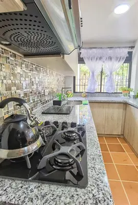 a kitchen with a stove with a tea kettle on it at Hermosa casa de campo en GUATAPÉ in Guatapé