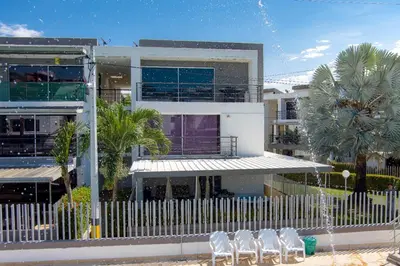 a row of white chairs in front of a building at Apartasol Ciudadela Santa Fé in Santa Fe de Antioquia
