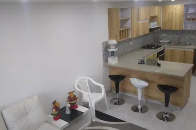 a kitchen with a counter and a table and chairs at Apartamento acogedor para vacacionar o de trabajo in Rionegro