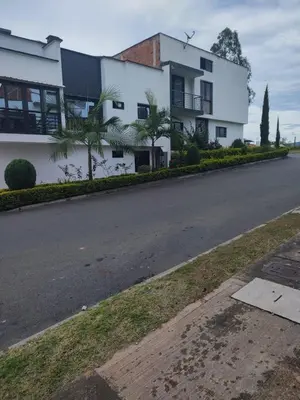 an empty street in front of a white building at Apartamento acogedor para vacacionar o de trabajo in Rionegro