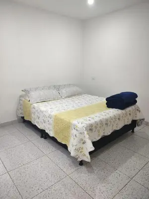 a bed with a blanket on it in a room at Apartamento acogedor para vacacionar o de trabajo in Rionegro