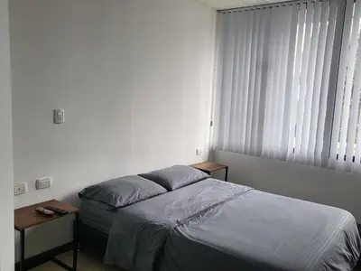 a bedroom with a bed and a window at Casa Azul - Apartamentos Amoblados - in Manizales