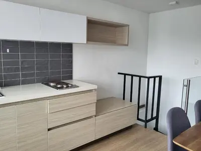 a kitchen with wooden cabinets and a counter top at Casa Azul - Apartamentos Amoblados - in Manizales