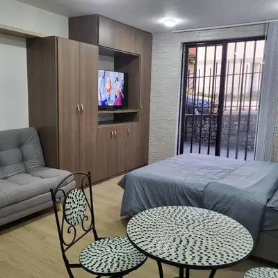 a bedroom with a bed and a table and chairs at Casa Azul - Apartamentos Amoblados - in Manizales
