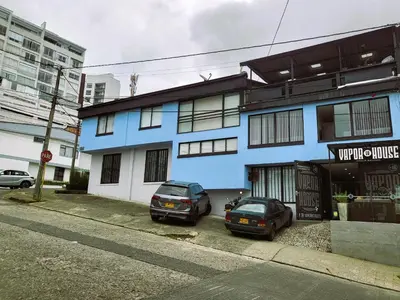 two cars parked in front of a blue building at Casa Azul - Apartamentos Amoblados - in Manizales