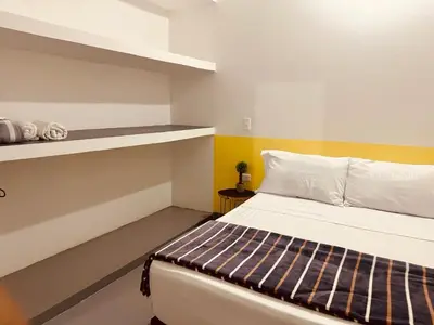 a small room with a bed and a shelf at Aloja-T en Apartamento amoblado SIN balcón en Ciudad Bolivar in Ciudad Bolívar