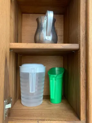 two cups and a vase on a wooden shelf at Aloja-T en Apartamento amoblado SIN balcón en Ciudad Bolivar in Ciudad Bolívar