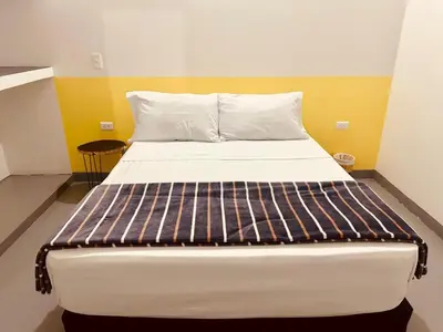a large bed in a small room with yellow walls at Aloja-T en Apartamento amoblado SIN balcón en Ciudad Bolivar in Ciudad Bolívar