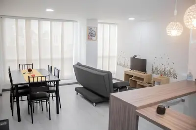 a living room with a table and chairs and a television at Apartamentos cómodos en Milan zona G in Manizales