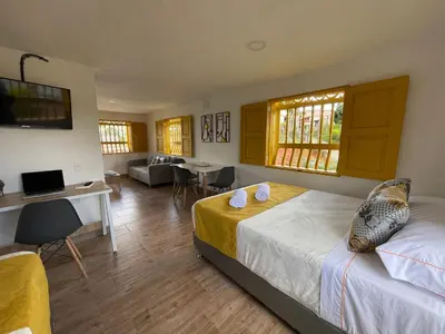 a bedroom with a bed and a living room at Palmar de Jericó Suites in Jericó