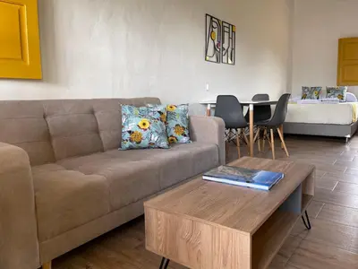 a living room with a couch and a table at Palmar de Jericó Suites in Jericó